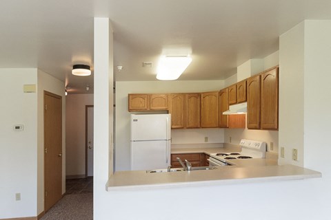 a kitchen with white appliances and wooden cabinets