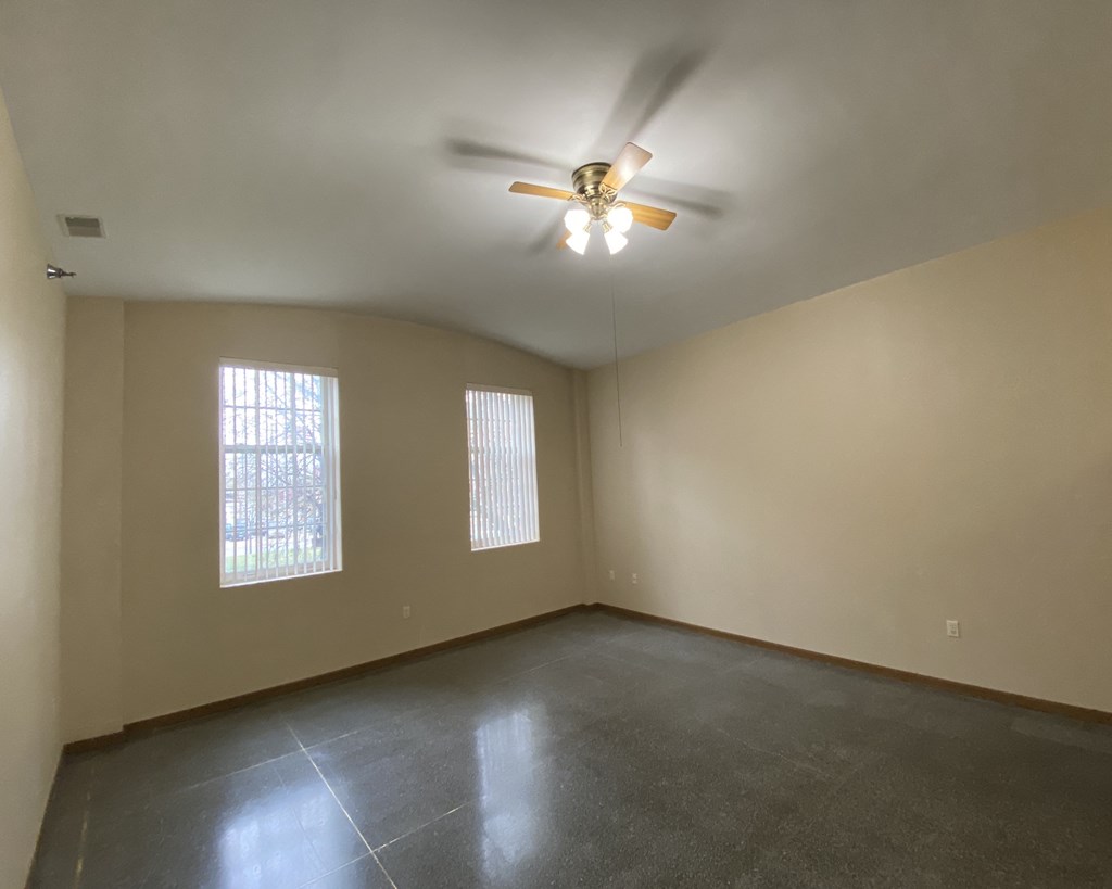 the living room of an empty house with a ceiling fan