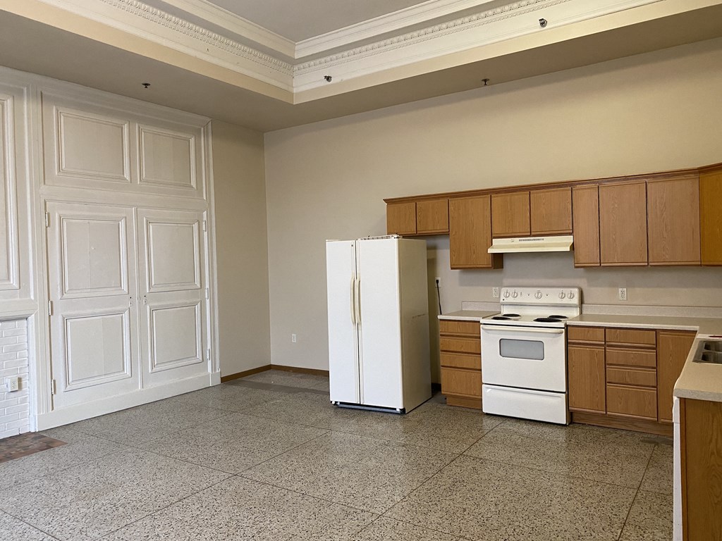 a kitchen with white appliances and wooden cabinets and a white refrigerator