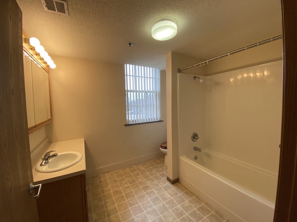 a bathroom with a sink and a tub and a shower