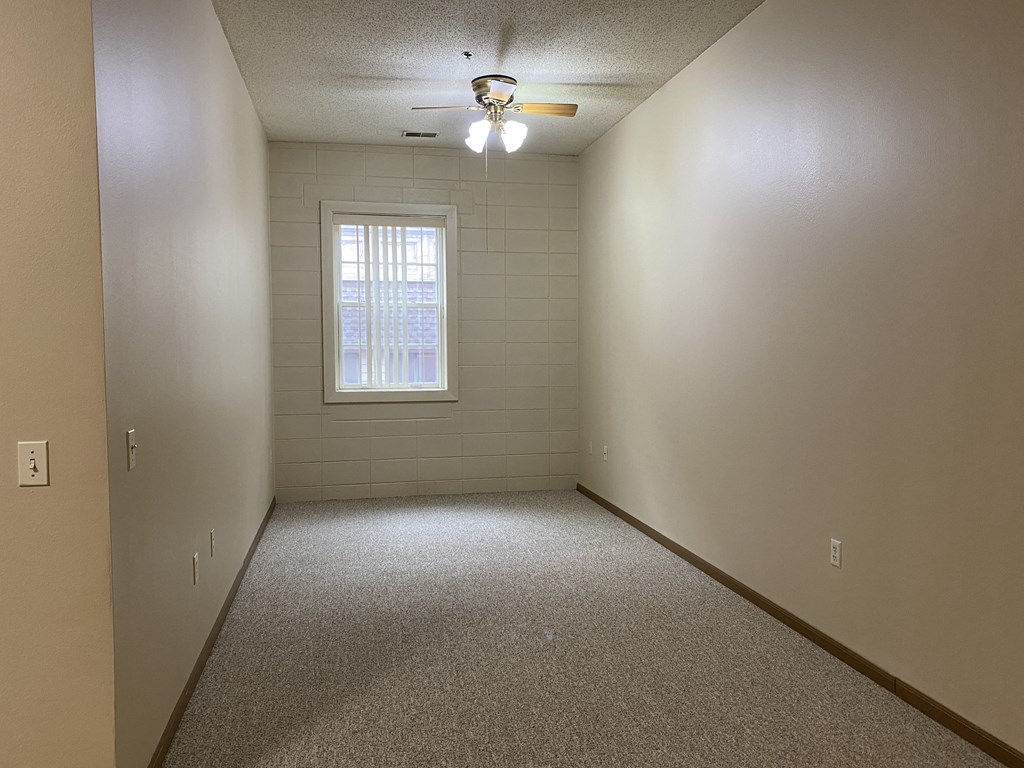 a empty room with a window and a ceiling fan
