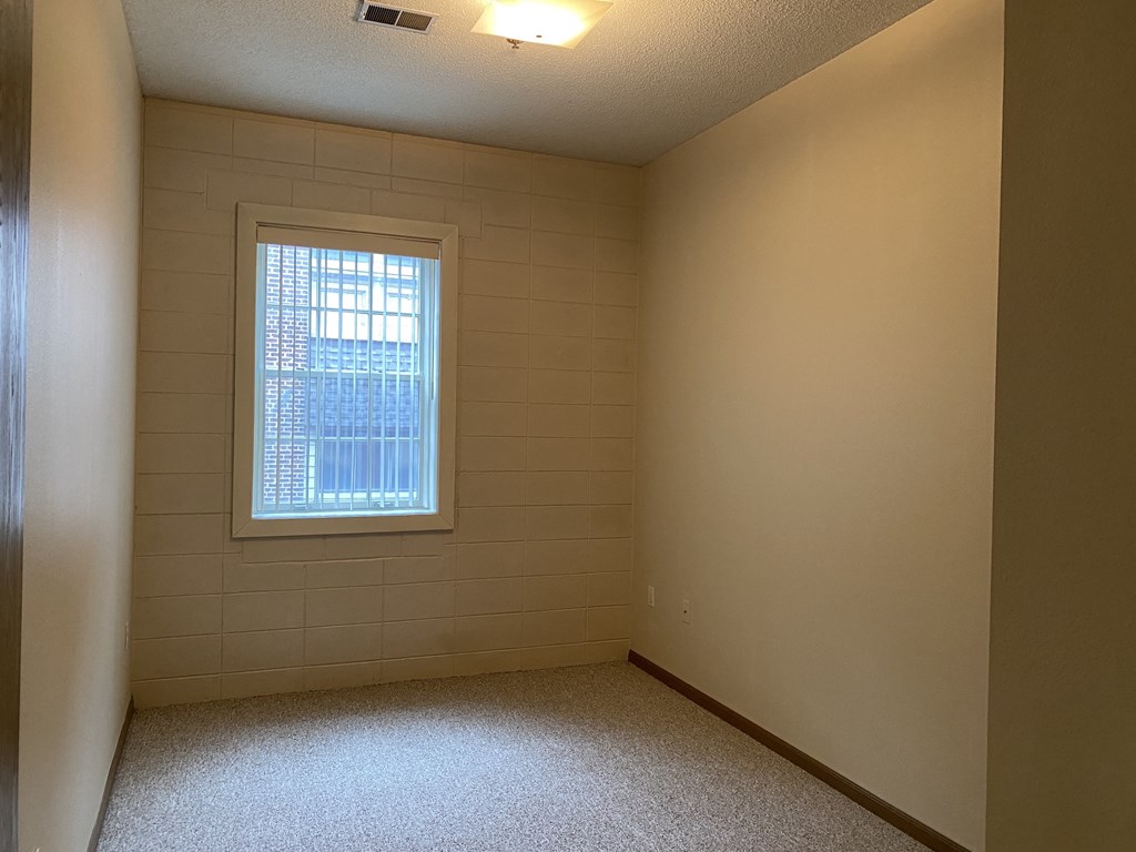 a room with a window and a carpeted floor