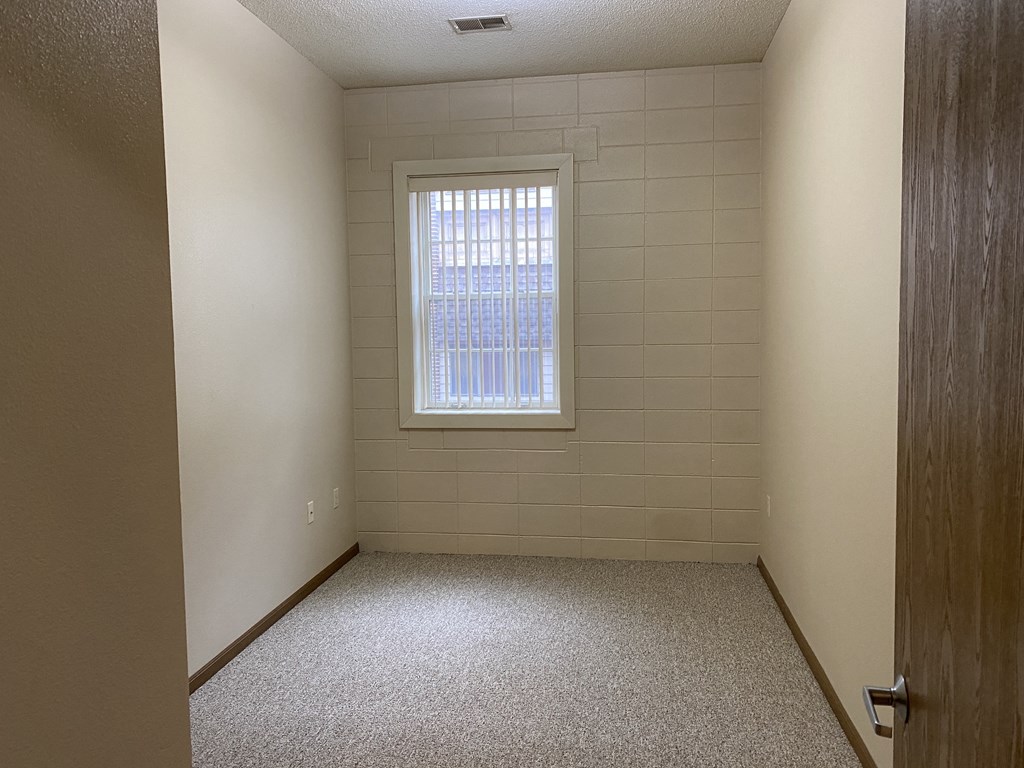 an empty room with a window and a door
