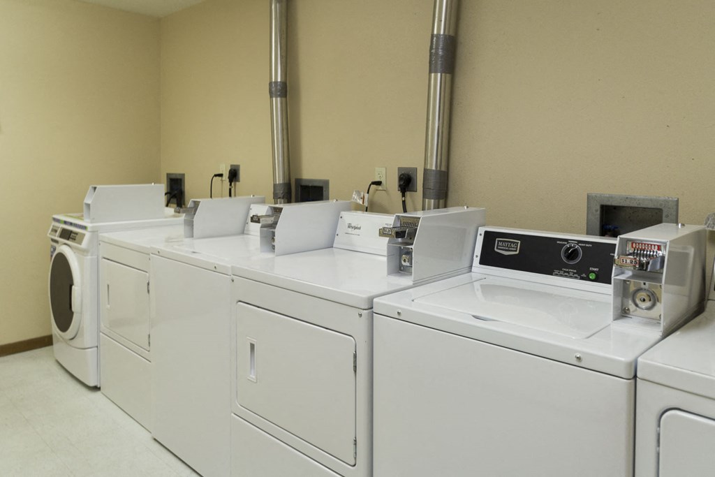 a row of white washing machines in a laundromat