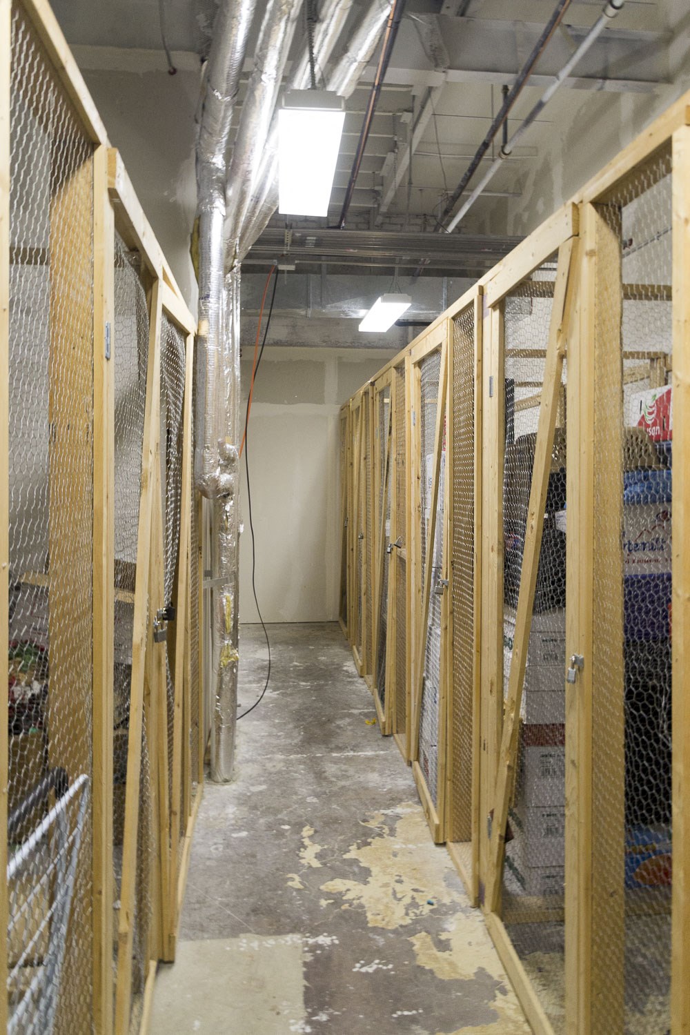 a hallway filled with racks of cages in a building