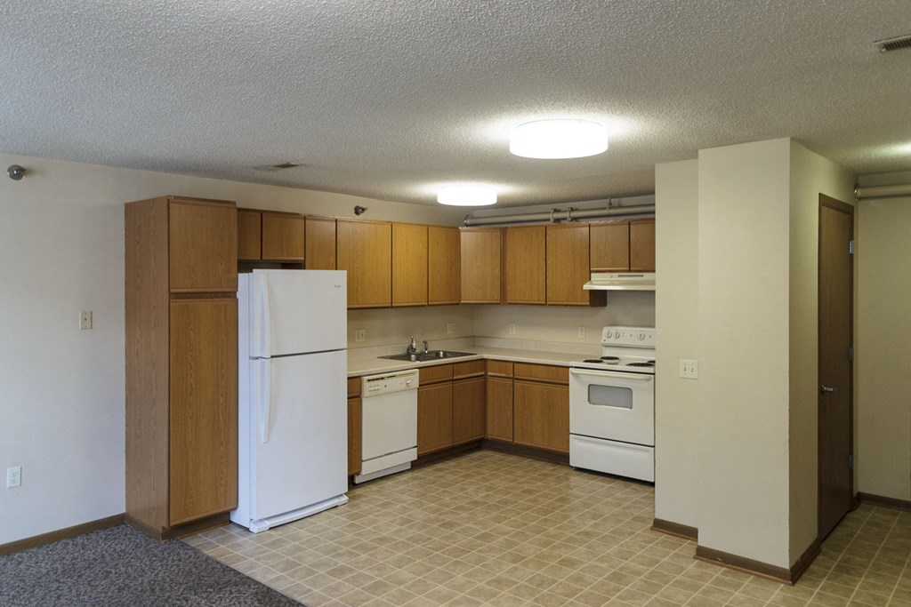a kitchen with white appliances and wooden cabinets