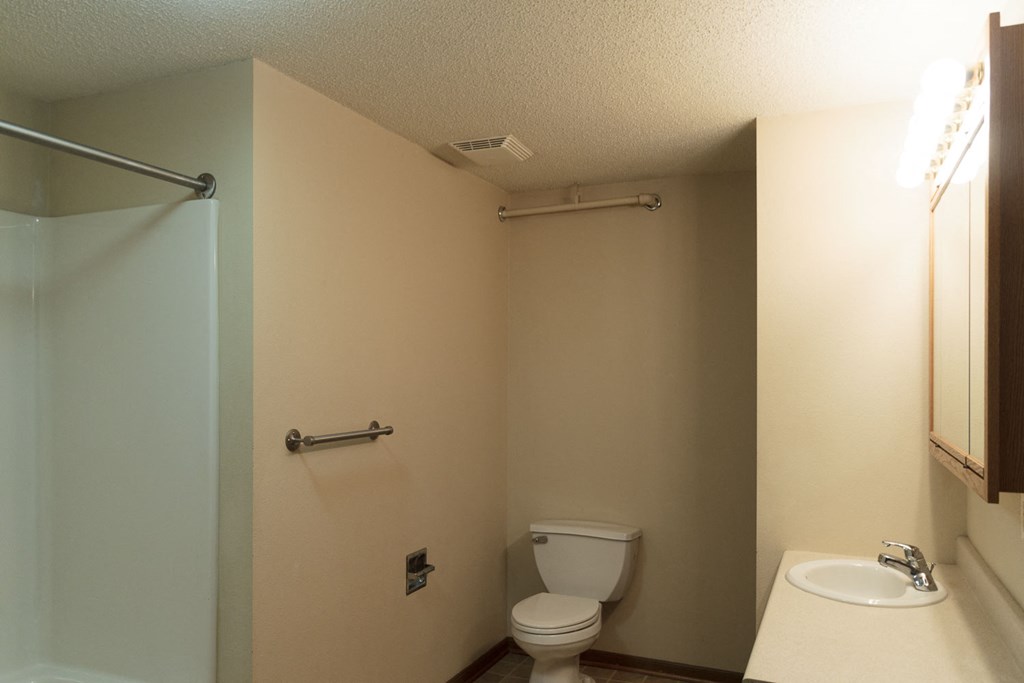 a bathroom with a toilet and a sink and a shower