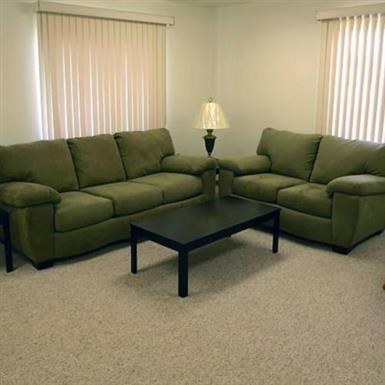 a living room with a green couch and a coffee table