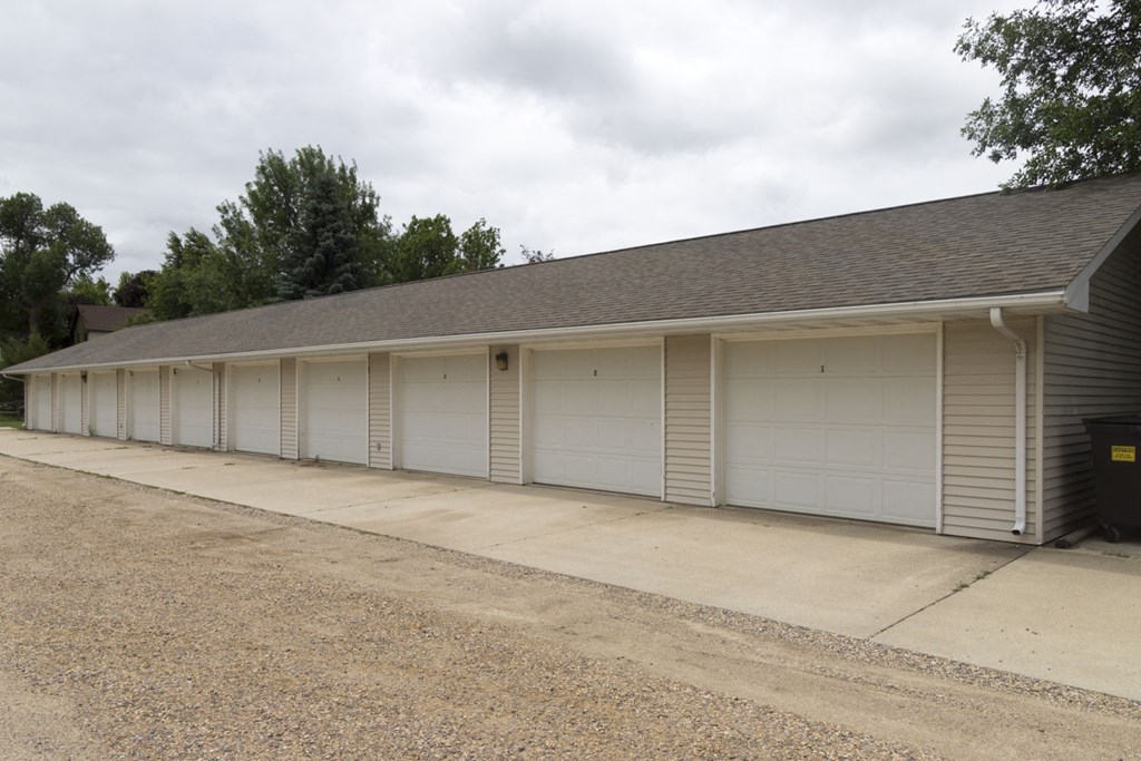 the front of a garage with a row of white doors