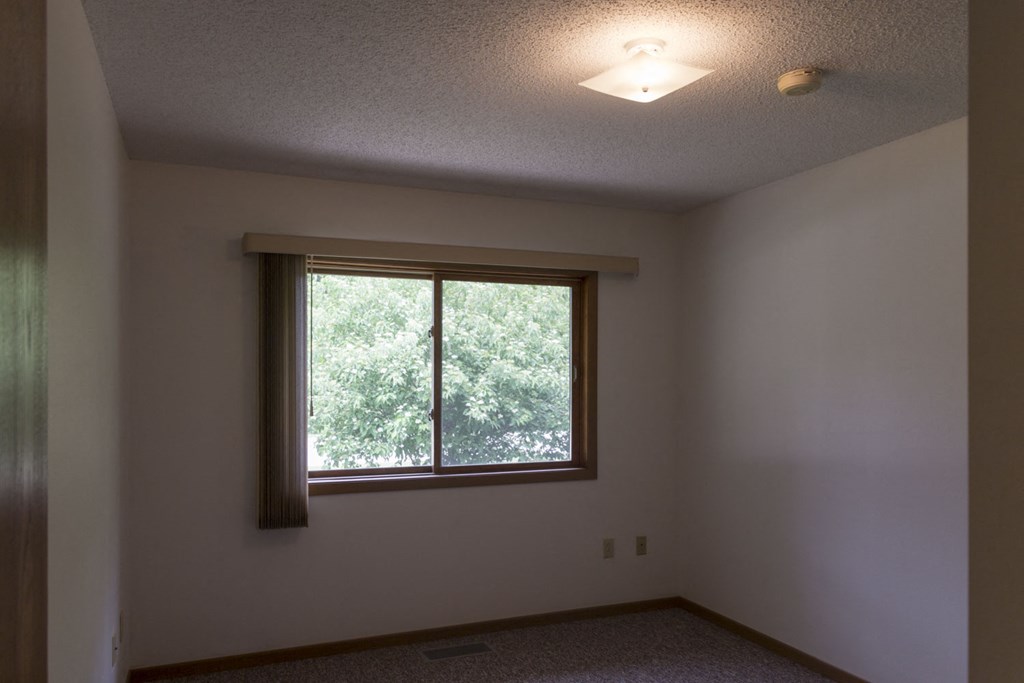 an empty room with a window and a light on the ceiling
