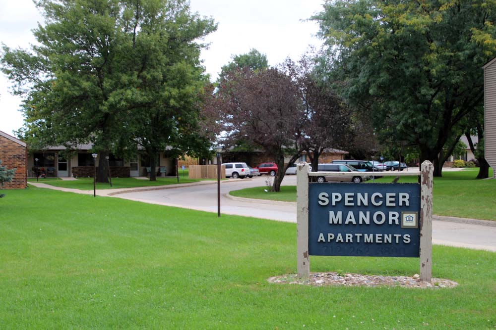 a sign that reads specer manor apartments in the grass