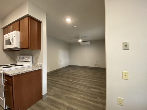 the kitchen and living room of an empty apartment