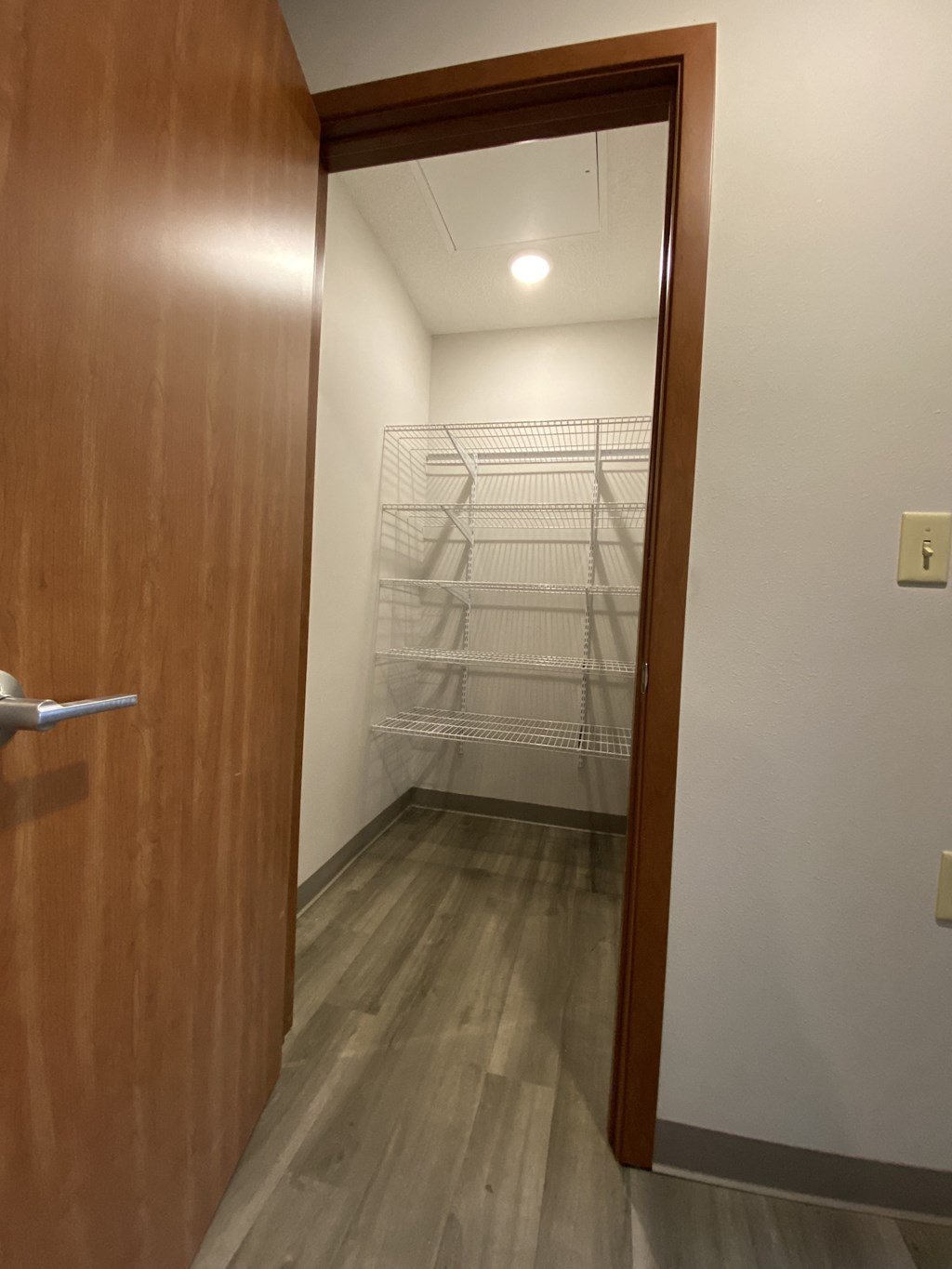 a walk in closet in a small room with a wooden door