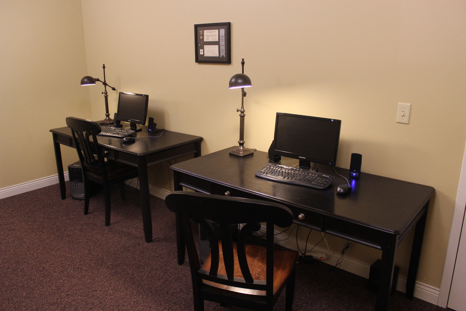 a home office with two desks and a computer