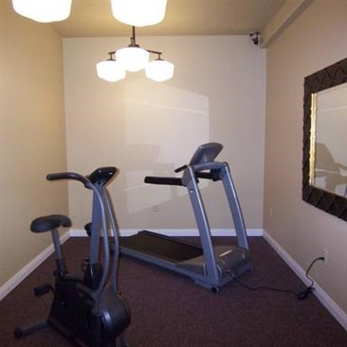 a home gym with a treadmill and lights
