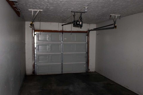 A garage with a white door and a white ceiling.