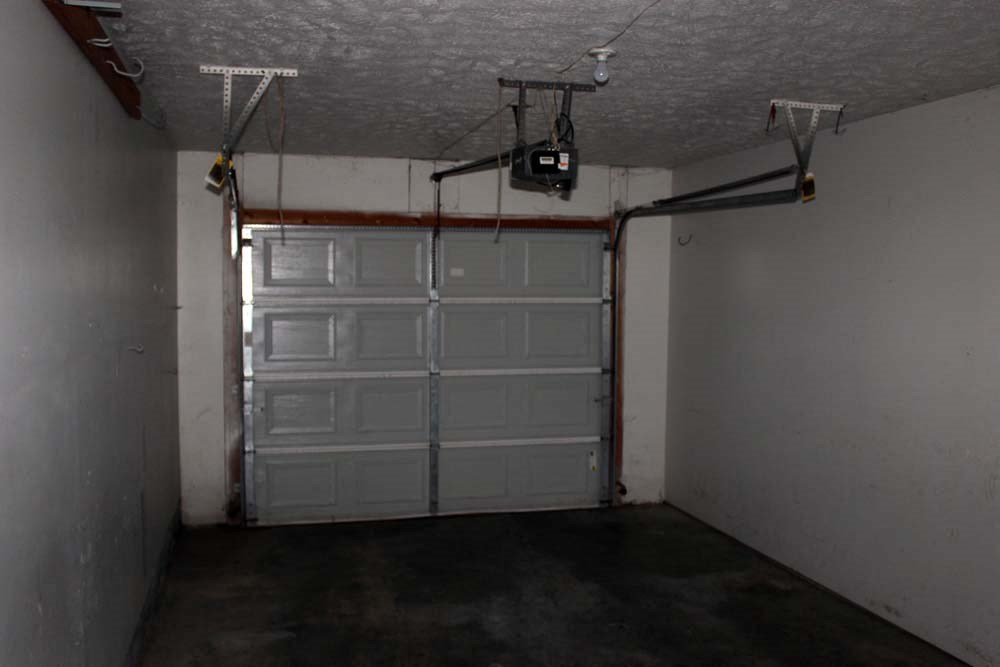 a garage with a white door and a projector on the ceiling