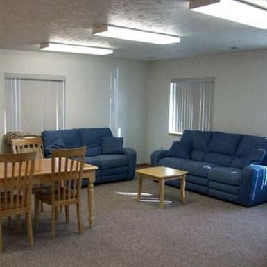a living room with blue couches and a table and chairs