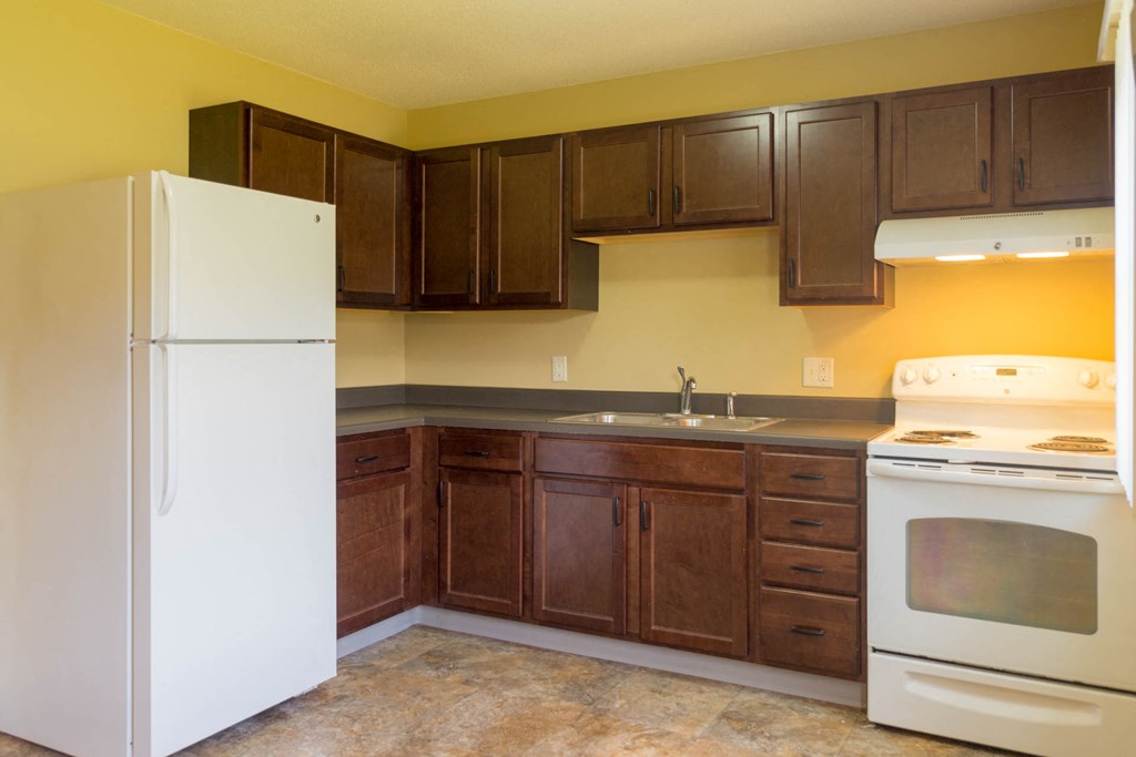 a kitchen with white appliances and wooden cabinets