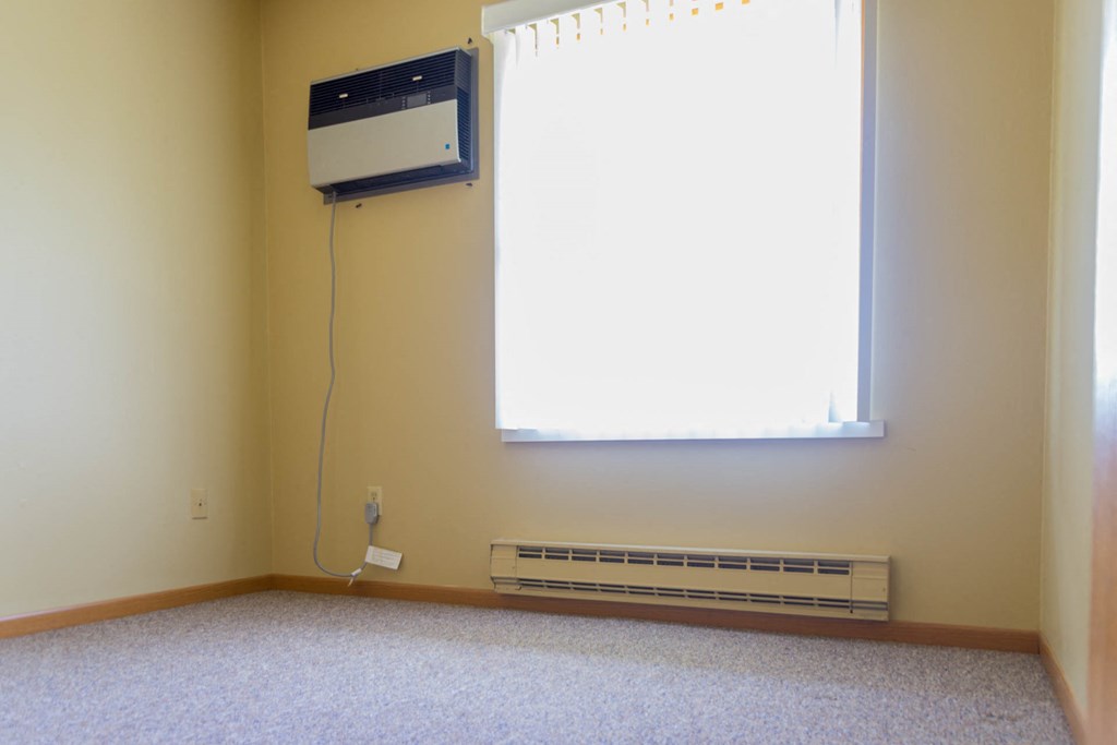 an empty room with a heater and a window