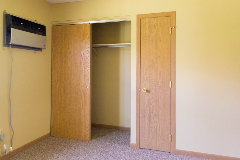 an empty room with a closet and a tv