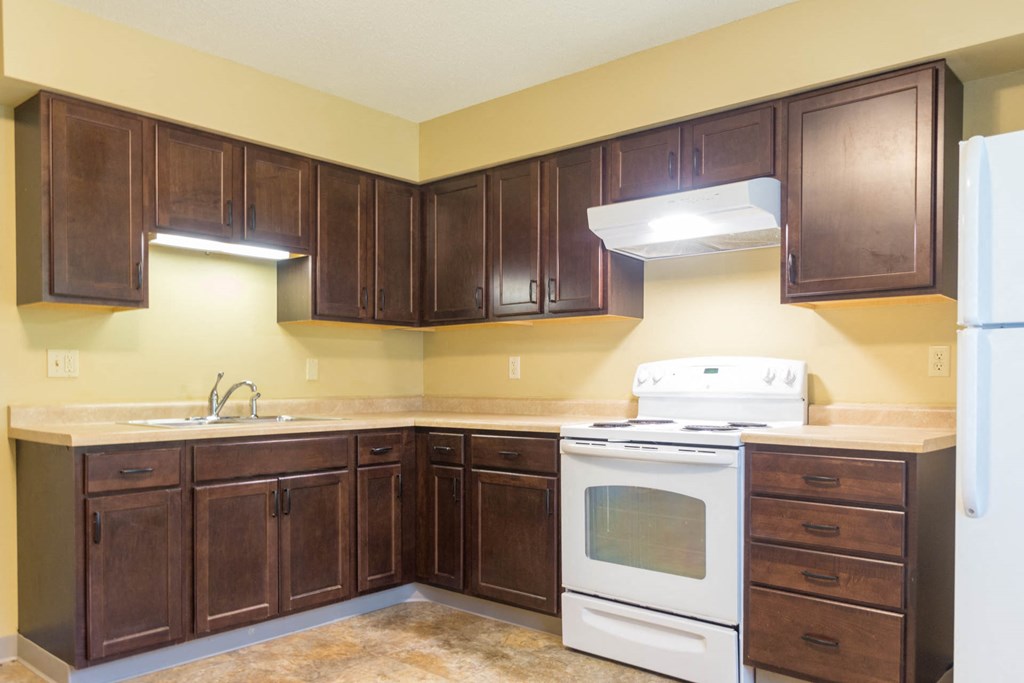 a kitchen with white appliances and wooden cabinets