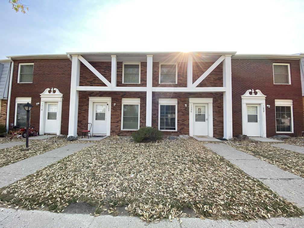 the front of a brick building with white doors