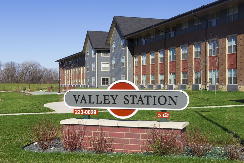 a sign for valley station in front of an apartment building