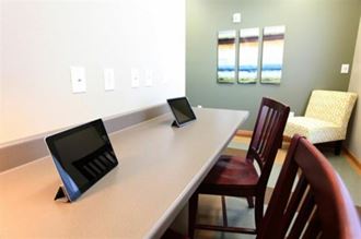 a desk with two laptops and chairs in a room