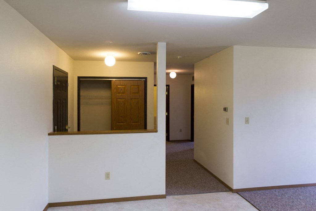 an empty living room with a mirror and a door