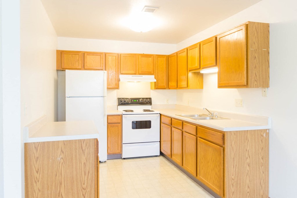 a kitchen with white appliances and wooden cabinets