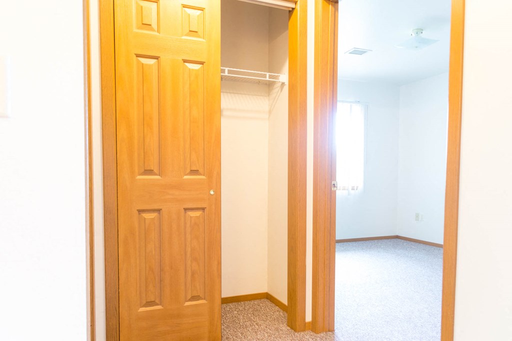 an empty closet in a room with a door open