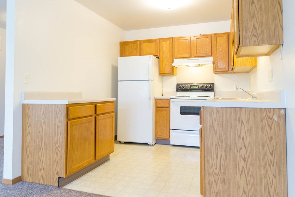 a kitchen with white appliances and wooden cabinets