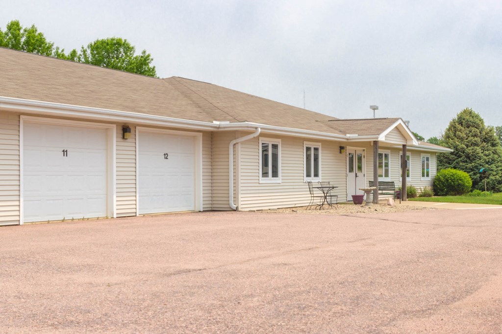 the front of a white house with two garage doors