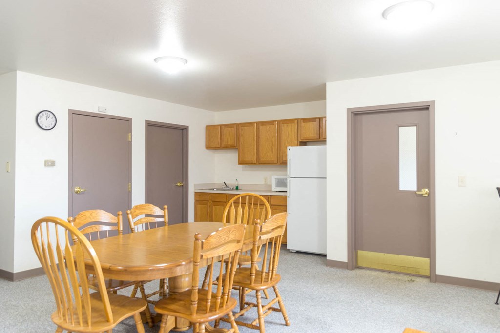 a dining room and kitchen with a table and chairs