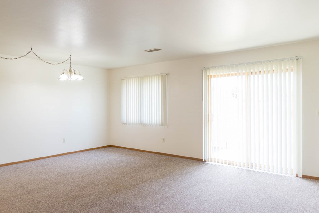 an empty living room with white walls and window