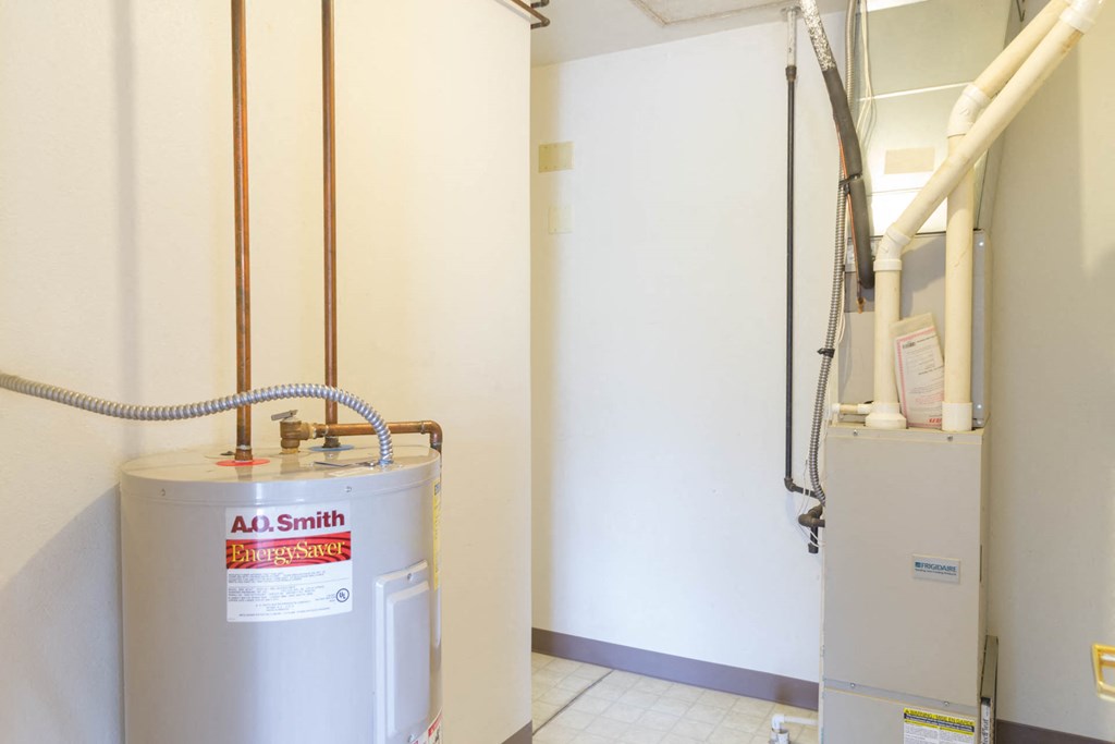 a water heater in a room next to a white wall