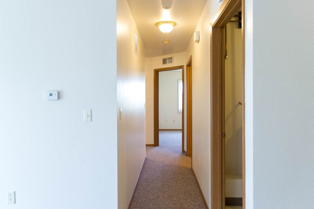 a hallway with a door to a bedroom and a closet