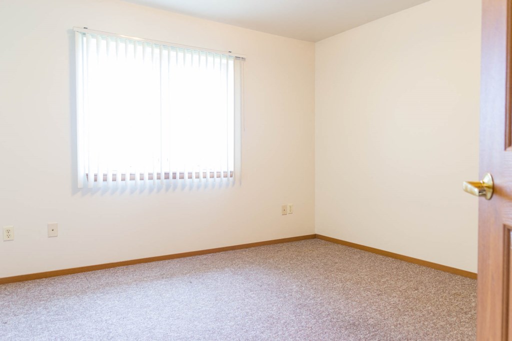 an empty room with a window and a door