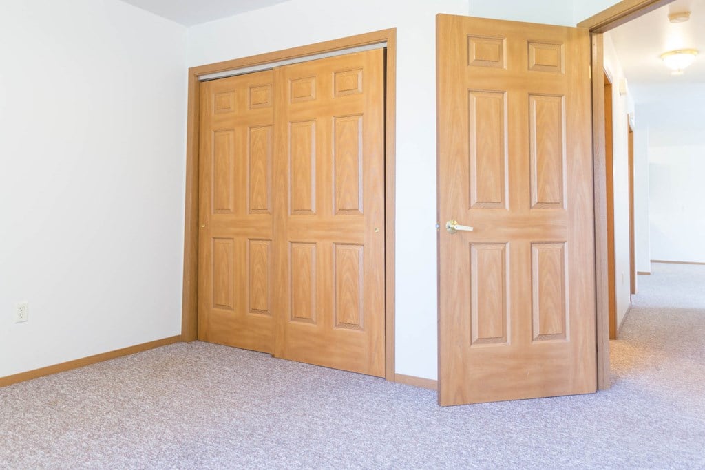 a pair of doors in a room next to a hallway