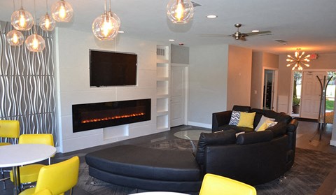 a living room with a black couch and a fireplace