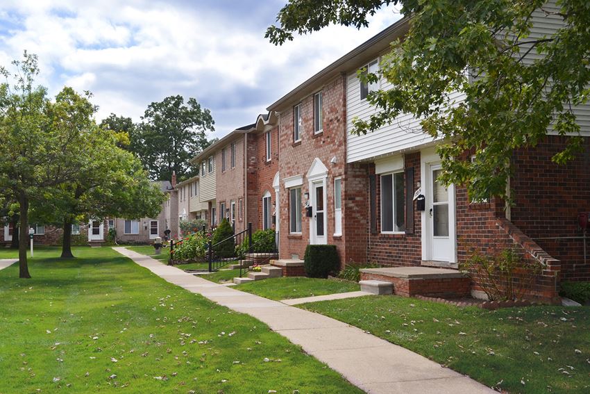 a sidewalk in front of a row of houses