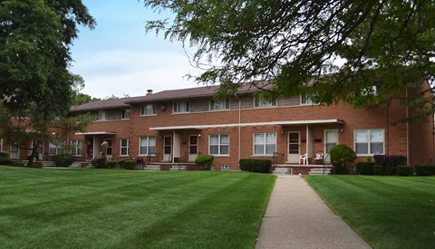 a large brick building with a lawn in front of it