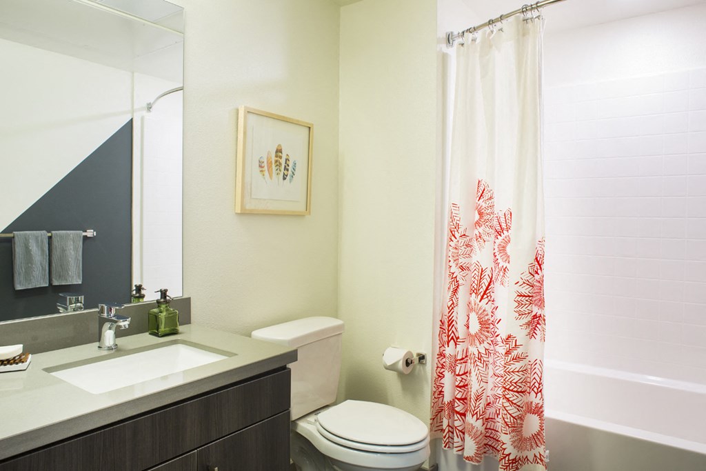 a bathroom with a shower curtain and a sink and a toilet
