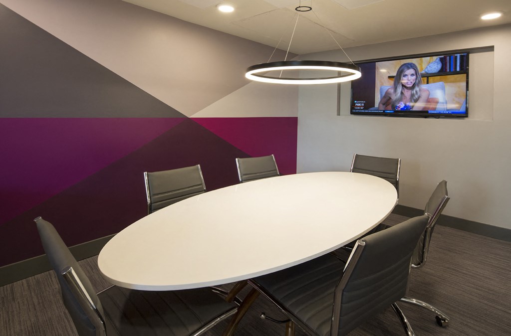 a conference room with a round table and a tv