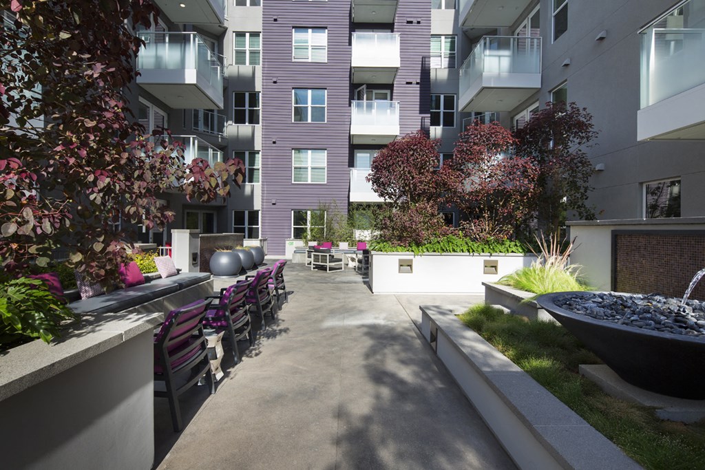 an outdoor area of an apartment building with chairs and a fountain