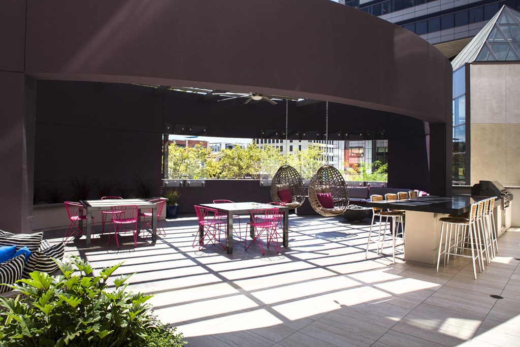 a patio with tables and chairs and a building in the background