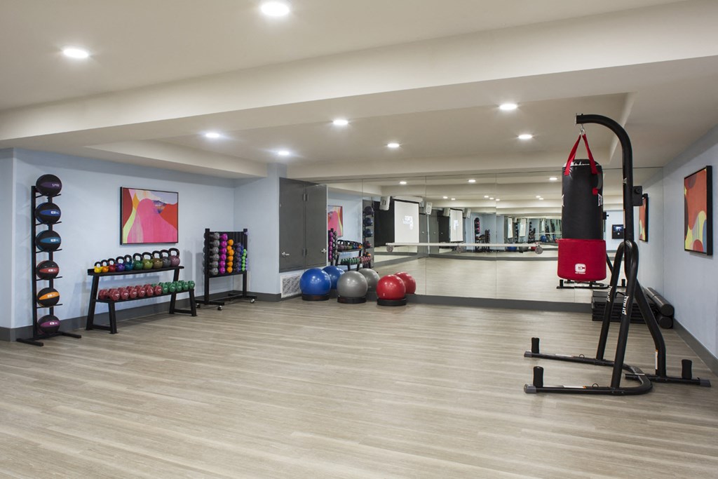 a gym with a punching bag and weights on the floor