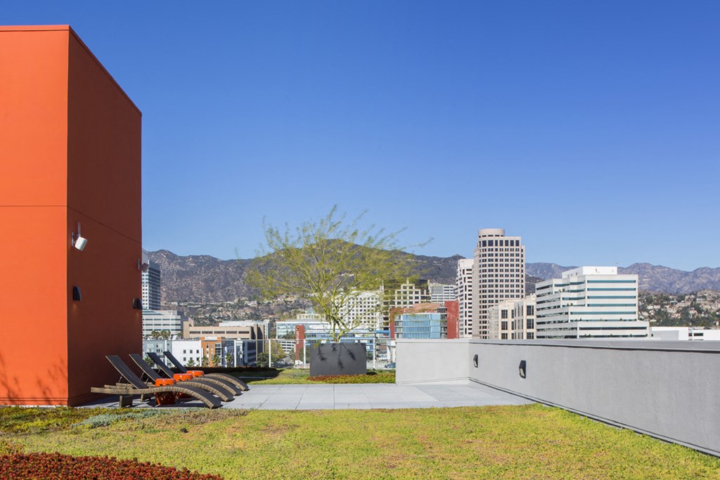 a roof terrace with a view of the city and mountains
