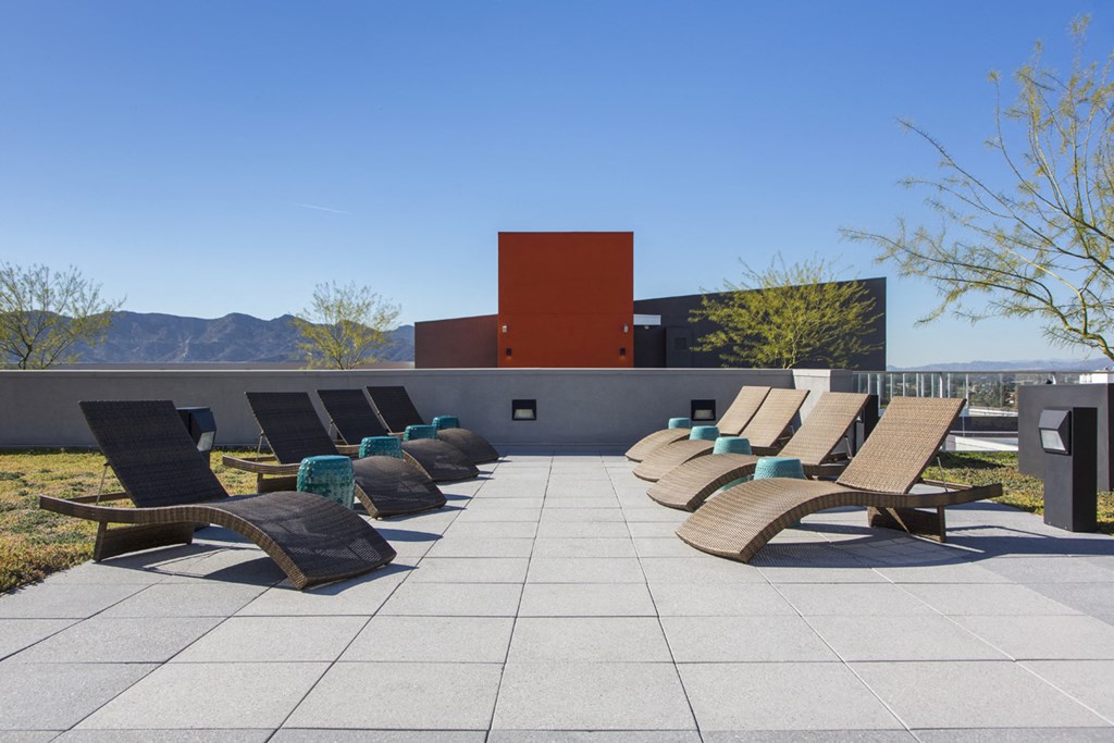 a row of lounge chairs on the roof of a building